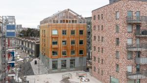 uma vista superior de um edifício de tijolos alto ao lado de dois edifícios em HomeX Hotel for Gamers em Täby