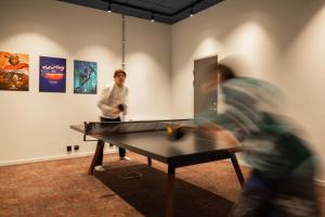 dos hombres jugando ping pong en una habitación con una mesa en HomeX Hotel for Gamers en Täby