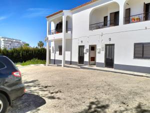 een auto geparkeerd voor een wit gebouw bij 2 Quinta Lamy - Casas & Papéis in Porches