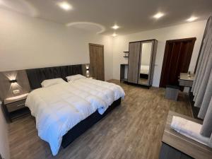 Al QasţalCaprios motel的卧室里有一张白色的大床和一面镜子