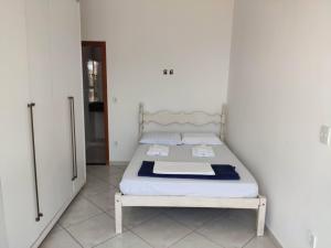 um pequeno quarto com uma cama num quarto em Casa Vista do Mar, praia e piscina em Vila Velha