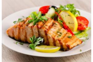 a plate of food with fish and vegetables on a table at Plus Hotel Express in Istanbul