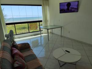 uma sala de estar com um sofá e uma mesa de vidro em Casa Vista do Mar, praia e piscina em Vila Velha