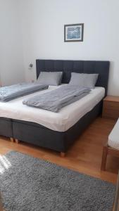 un lit avec une tête de lit noire dans une chambre dans l'établissement Appartement Huber, à Lutzmannsburg
