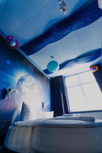 a room with an astronaut themed bedroom with a window at LaLeLu Hostel Dresden in Dresden