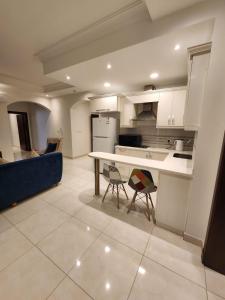 Sama Residence في الخبر: مطبخ مع طاولة وأريكة زرقاء في غرفة