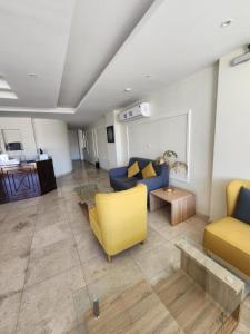 Sama Residence في الخبر: غرفة معيشة مع أريكة زرقاء وكراسي صفراء