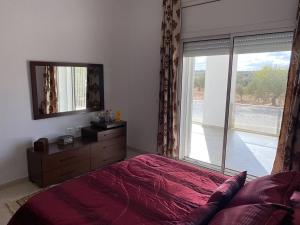 a bedroom with a bed and a large window at Cheerful 2-bedroom Villa with pool 