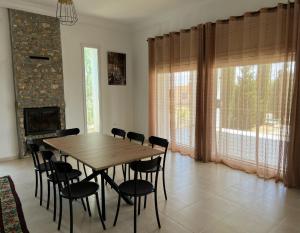 a dining room with a wooden table and chairs at Cheerful 2-bedroom Villa with pool 