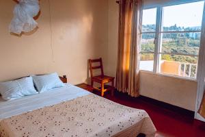 a bedroom with a bed and a window and a chair at MOUCECORE in Kigali