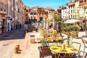 a city street with tables and chairs and buildings at Campagne de Saint Clair in Pertuis