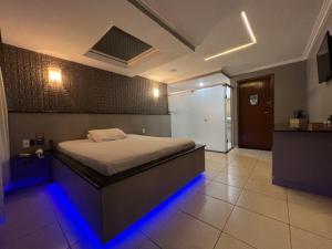 um quarto com uma cama com luzes azuis em Gran Motel em Taguatinga