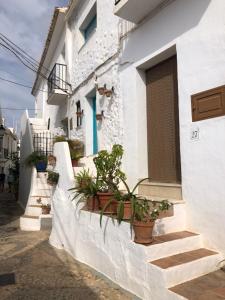 un edificio blanco con escaleras y macetas. en Apartment Casa Lila 100m from the beach, en Torrox Costa