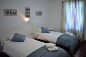 um quarto de hotel com duas camas com almofadas azuis em Madeira, 3 bedroom apartment with ocean views in Funchal no Funchal