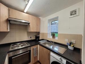 a small kitchen with a sink and a stove at Tastefully decorated 1 bed flat near AbbeyWood in Belvedere