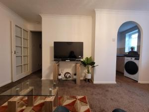 uma sala de estar com uma televisão de ecrã plano na parede em Tastefully decorated 1 bed flat near AbbeyWood em Belvedere