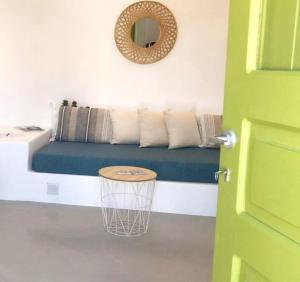 a room with a blue couch with pillows and a mirror at Finikas Cave House in Foinikiá