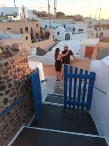 two women walking down a stairway with a blue chair at Finikas Cave House in Foinikiá