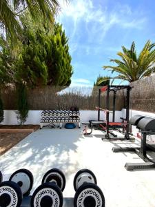 einen Hinterhof mit einem Fitnessraum mit einem Haufen Gewichten in der Unterkunft Celebrate Life's Precious Moments at Can Saca! in Sant Jordi