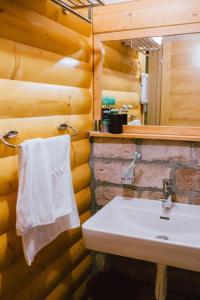 ein Bad mit einem Waschbecken und einem weißen Handtuch in der Unterkunft Treehouse Bosnia in Trnovo