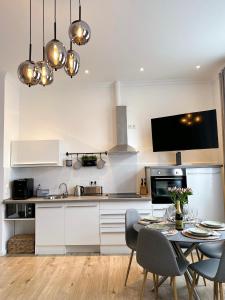 a kitchen with a table and chairs and a kitchen with white cabinets at Ferienwohnung Strandläufer in Wilhelmshaven +38 photos