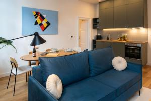 a living room with a blue couch and a kitchen at Design Apartments near Botanical Garden in Zagreb