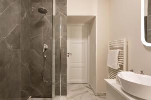 La salle de bains est pourvue d'une douche et d'un lavabo. dans l'établissement Design Apartments near Botanical Garden, à Zagreb