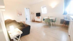 uma sala de estar com um sofá e uma mesa em Appartement avec piscine, 100m plage et hypercentre em Cabourg