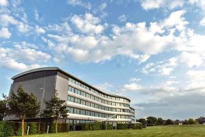 a large building with a grass field in front of it at Aviator in Farnborough
