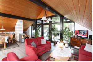un soggiorno con divano rosso e tavolo di Haus Sonnenhügel a Winterberg