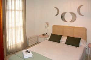 - une chambre avec un lit et un miroir mural dans l'établissement Apartamento Calle Feria, à Séville
