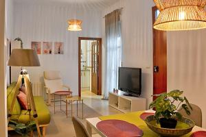 - un salon avec un canapé et une télévision dans l'établissement Apartamento Calle Feria, à Séville