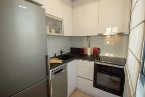 uma cozinha com armários brancos e um forno com placa de fogão em GARDOS BAUHAUS Apartment em Belgrado