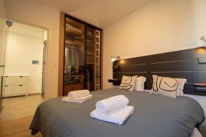una camera da letto con un grande letto con asciugamani di GARDOS BAUHAUS Apartment a Belgrado