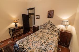 a bedroom with a bed and a desk with a lamp at Finca casa rural de la Mata in Toledo