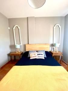 a bedroom with a large bed with two mirrors at Ático Islantilla Golf in Islantilla
