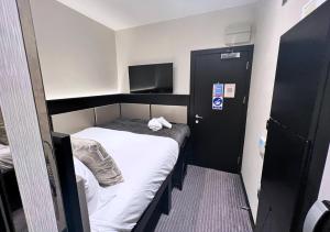 a small room with a bed and a tv at Great St Helen Hotel in London