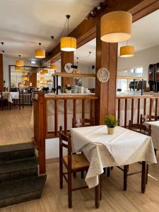 フォルミガルにあるHotel Tirolのテーブルと椅子、カウンター付きのレストラン