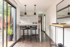 a kitchen with a bar with stools at Aromos Lodge- Chacras de Coria- in Ciudad Lujan de Cuyo