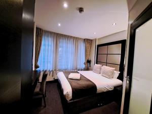 a hotel room with a bed and a window at Great St Helen Hotel in London