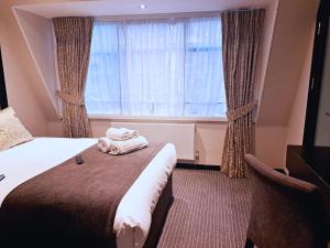 a hotel room with a bed and a window at Great St Helen Hotel in London