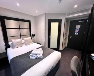 a hotel room with a bed with towels on it at Great St Helen Hotel in London