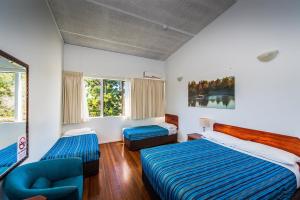 a bedroom with two beds and two windows at Diggers Tavern in Bellingen