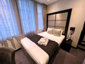 a bedroom with a bed with two towels on it at Great St Helen Hotel in London
