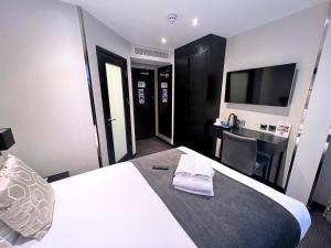 a hotel room with a bed and a desk and a television at Great St Helen Hotel in London