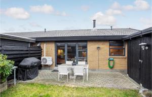 a patio with a table and chairs in front of a house at 2 Bedroom Nice Apartment In Skagen in Skagen