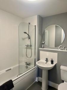 een badkamer met een douche, een wastafel en een spiegel bij Stylish 2 Bed Apartment Derby in Derby