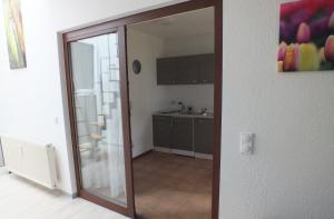 una puerta corredera de cristal en una habitación con cocina en Ferienwohnung Freyas Walderlebnis, en Stromberg