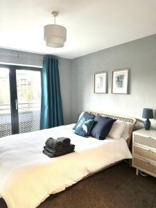 a bedroom with a large bed with blue curtains at Stylish 2 Bed Apartment Derby in Derby