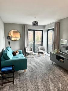 a living room with a green couch and chairs at Stylish 2 Bed Apartment Derby in Derby